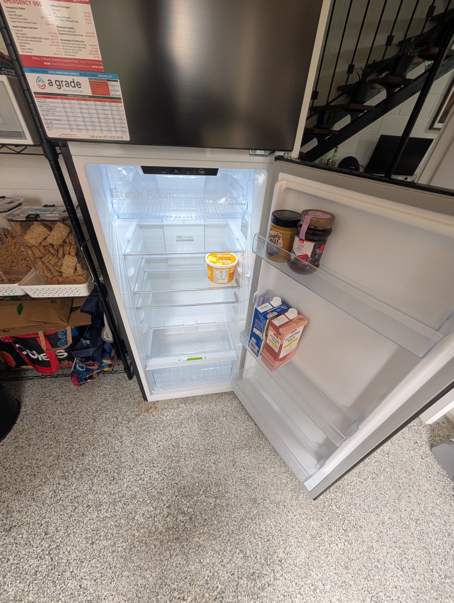 Fridge open showing clean empty shelves and door items