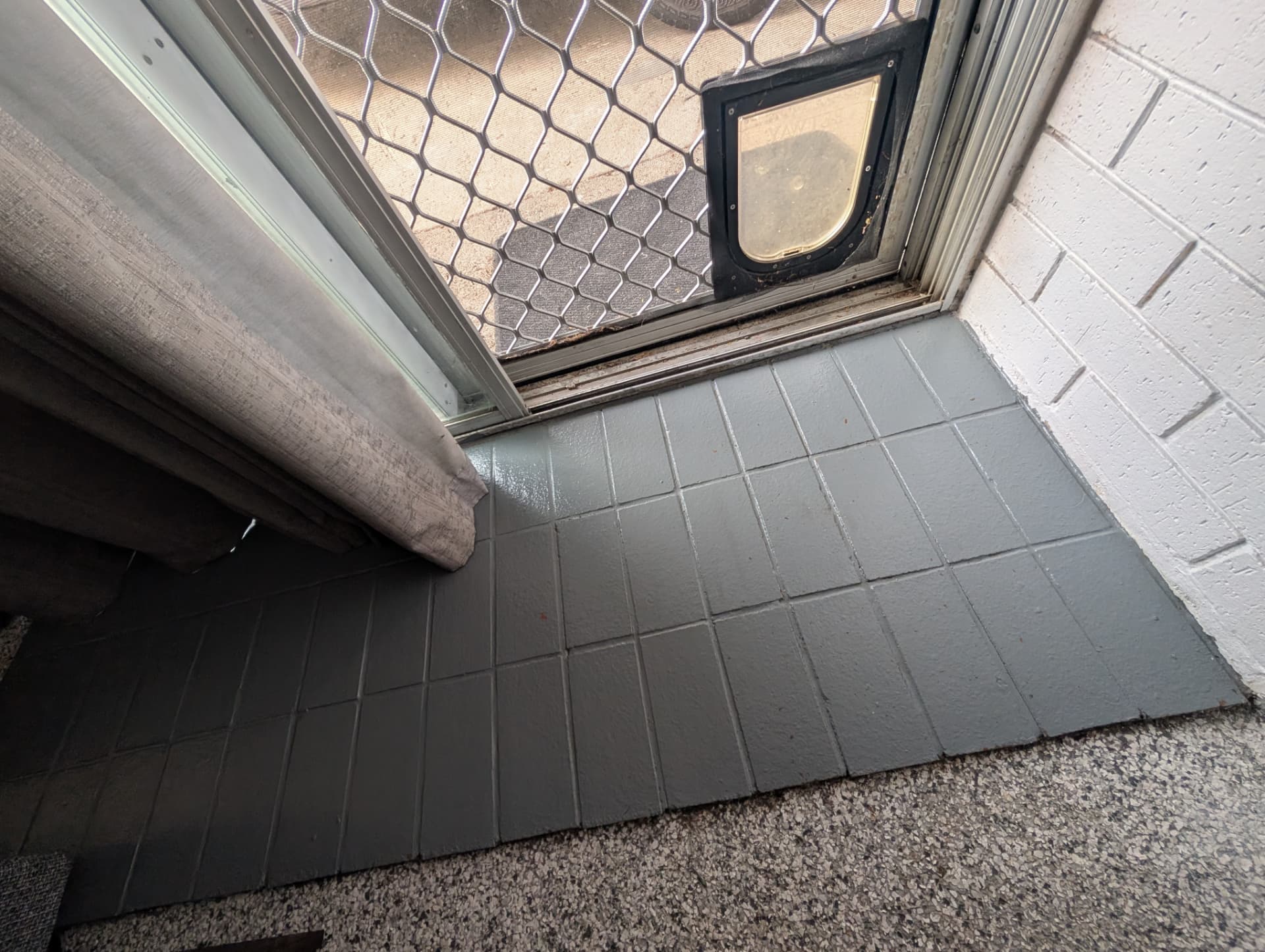 Entry doorway with clean tiled floor and screen door